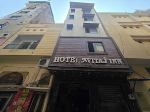 Ein Hotel mit einem Schild, auf dem 'HOTEL AVITAJ INN' steht, und einem sichtbaren Eingang.
