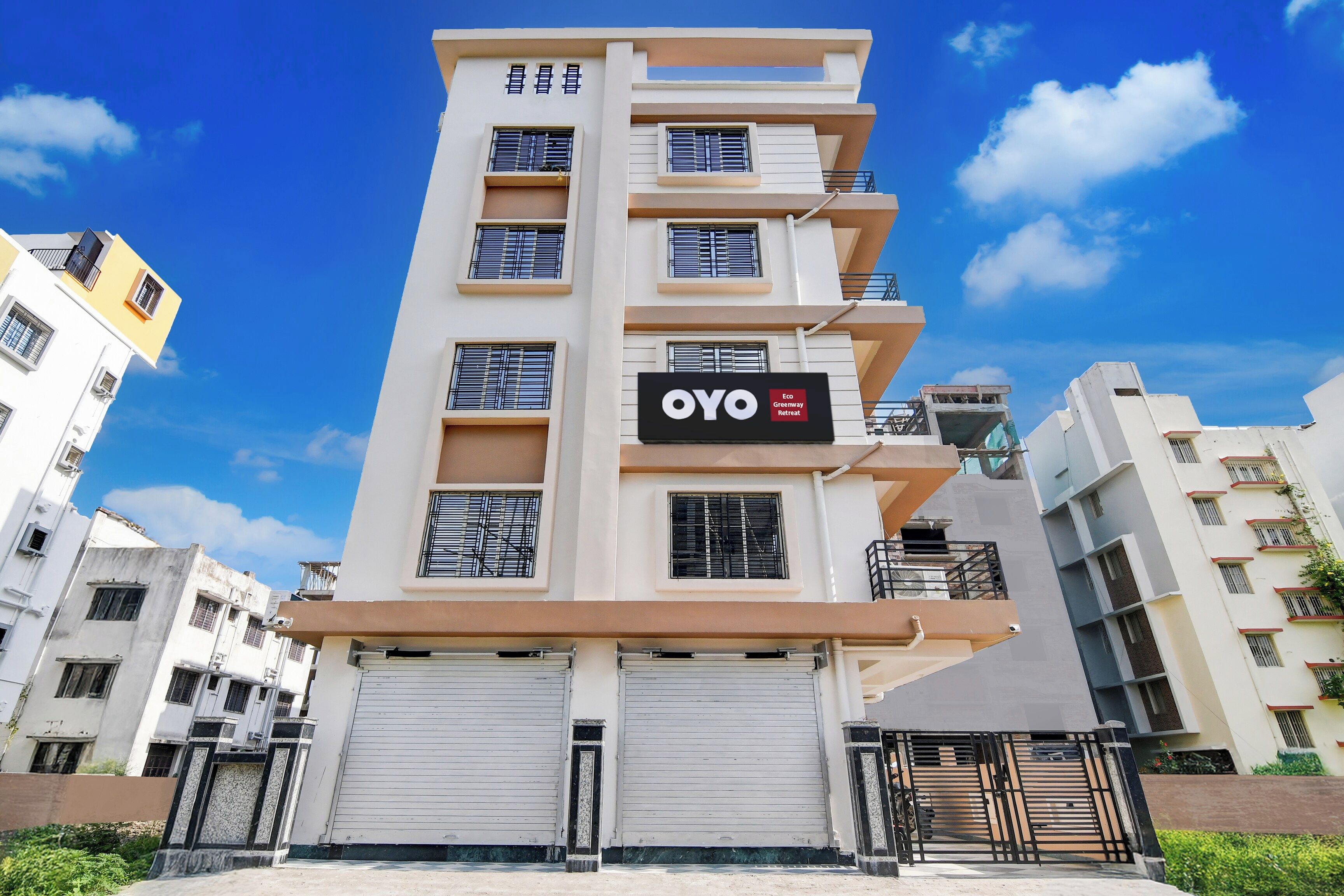 A multi-story building with a sign for 'OYO Eco Greenway Retreat'.