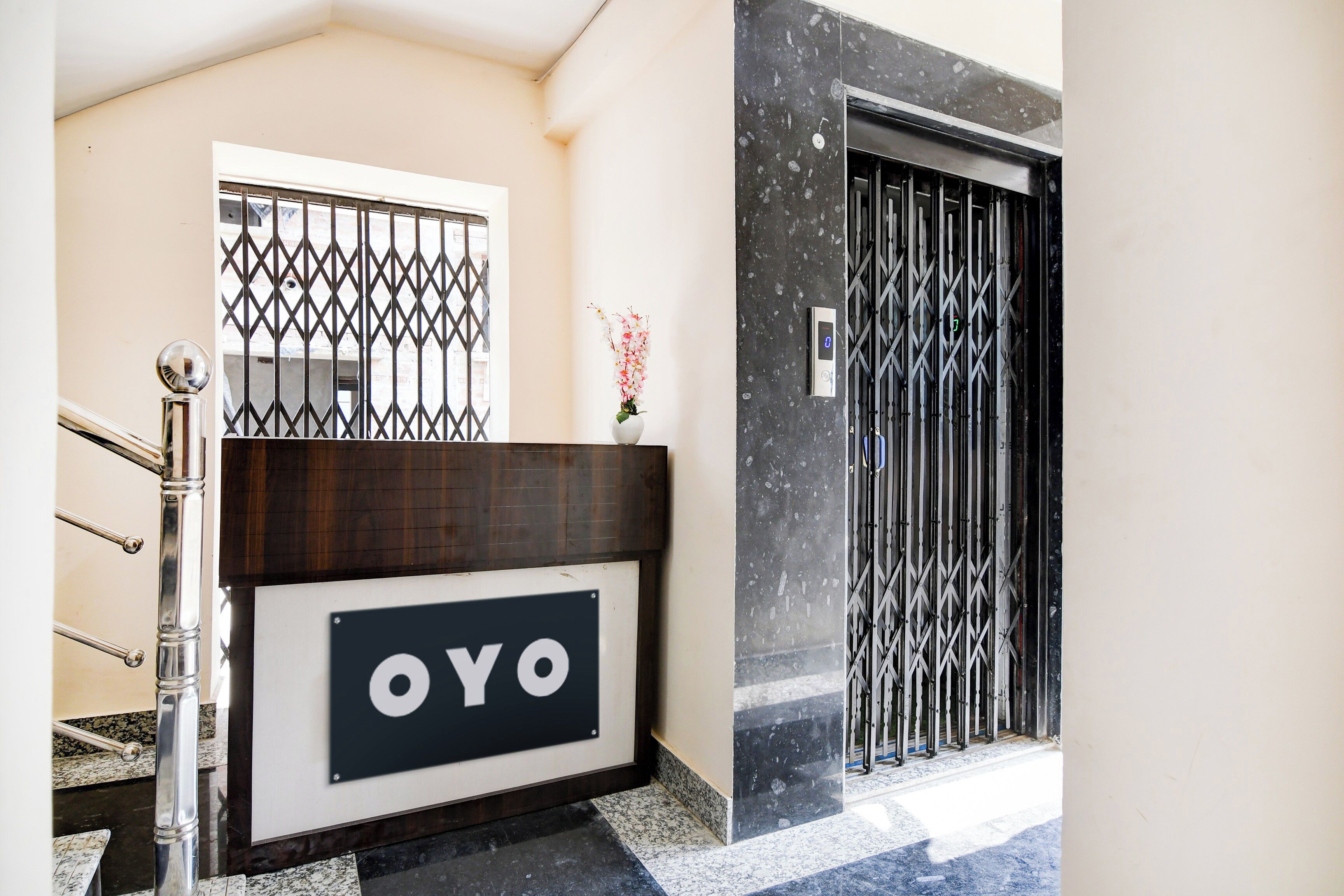 A reception area with a sign reading 'OYO' and a security gate.
