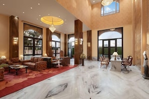A spacious lobby with a marble floor, comfortable seating, a reception desk, and large windows. - Justa Ssatvsa Resort & Spa Udaipur (Udaipur)