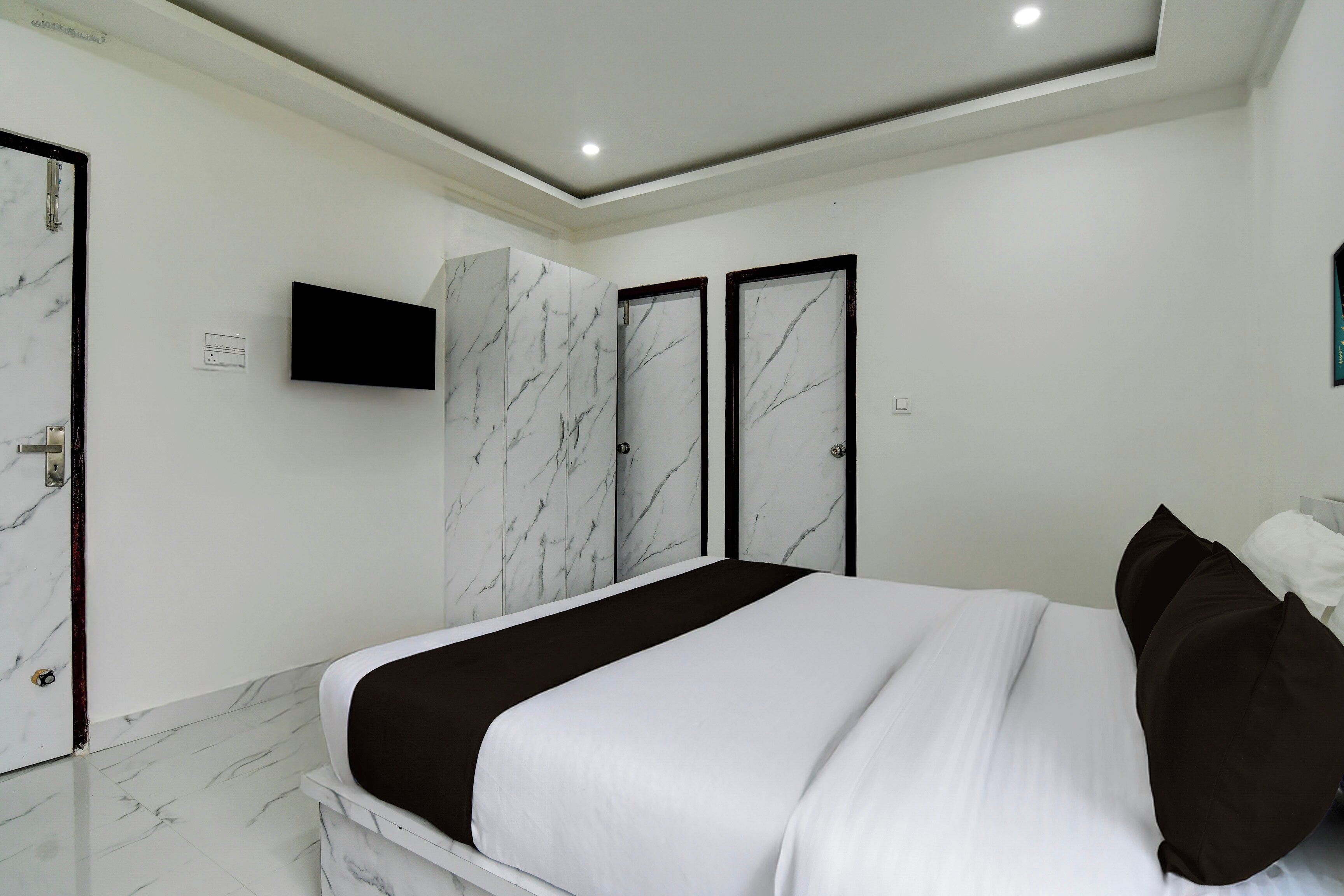 A bedroom with a bed, a television, and a wardrobe.