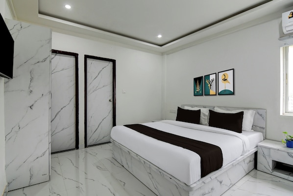 Un dormitorio moderno con una cama grande, un armario y una mesita de noche.
