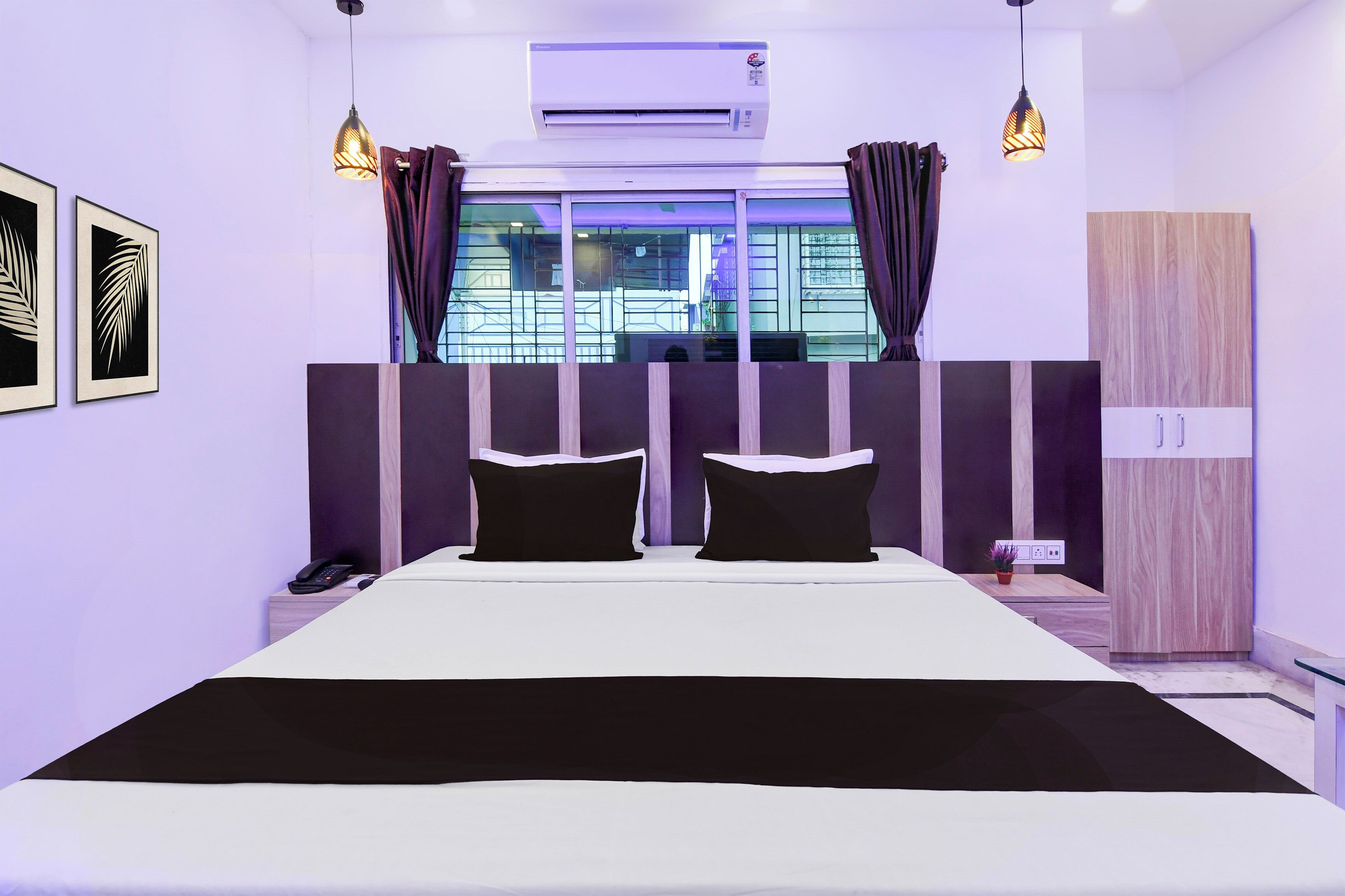 A modern bedroom with a large bed, two bedside tables, a wardrobe, and a window with curtains.