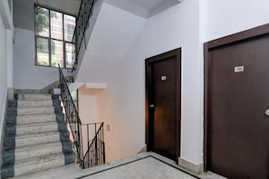 Eine Treppe mit Metallgeländer führt zu einer Zwischenebene, dort befinden sich eine Tür mit der Aufschrift '101' und eine weitere Tür mit der Aufschrift '102'.
