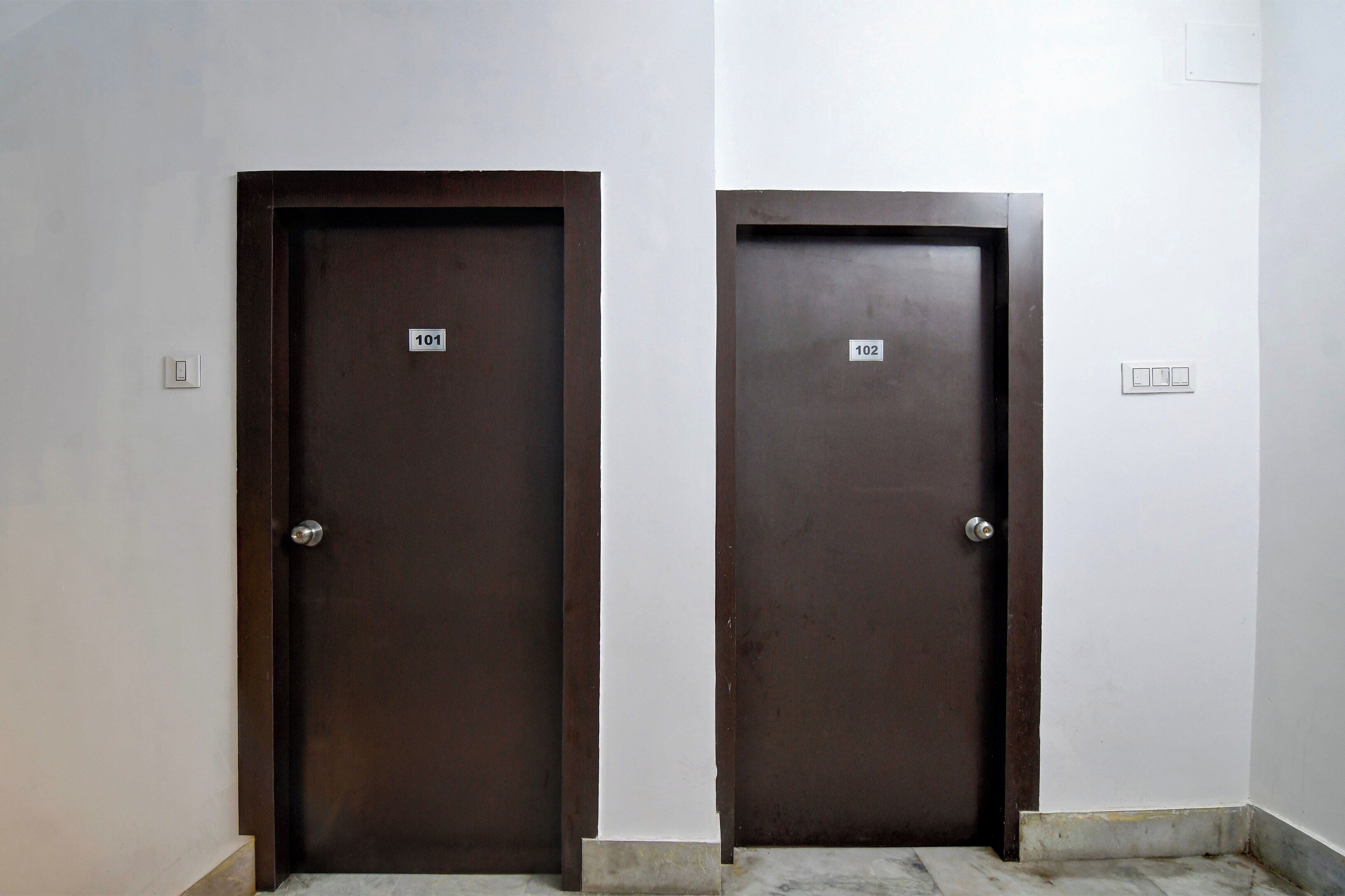 Two closed doors with numbers 101 and 102 on them, indicating room numbers.