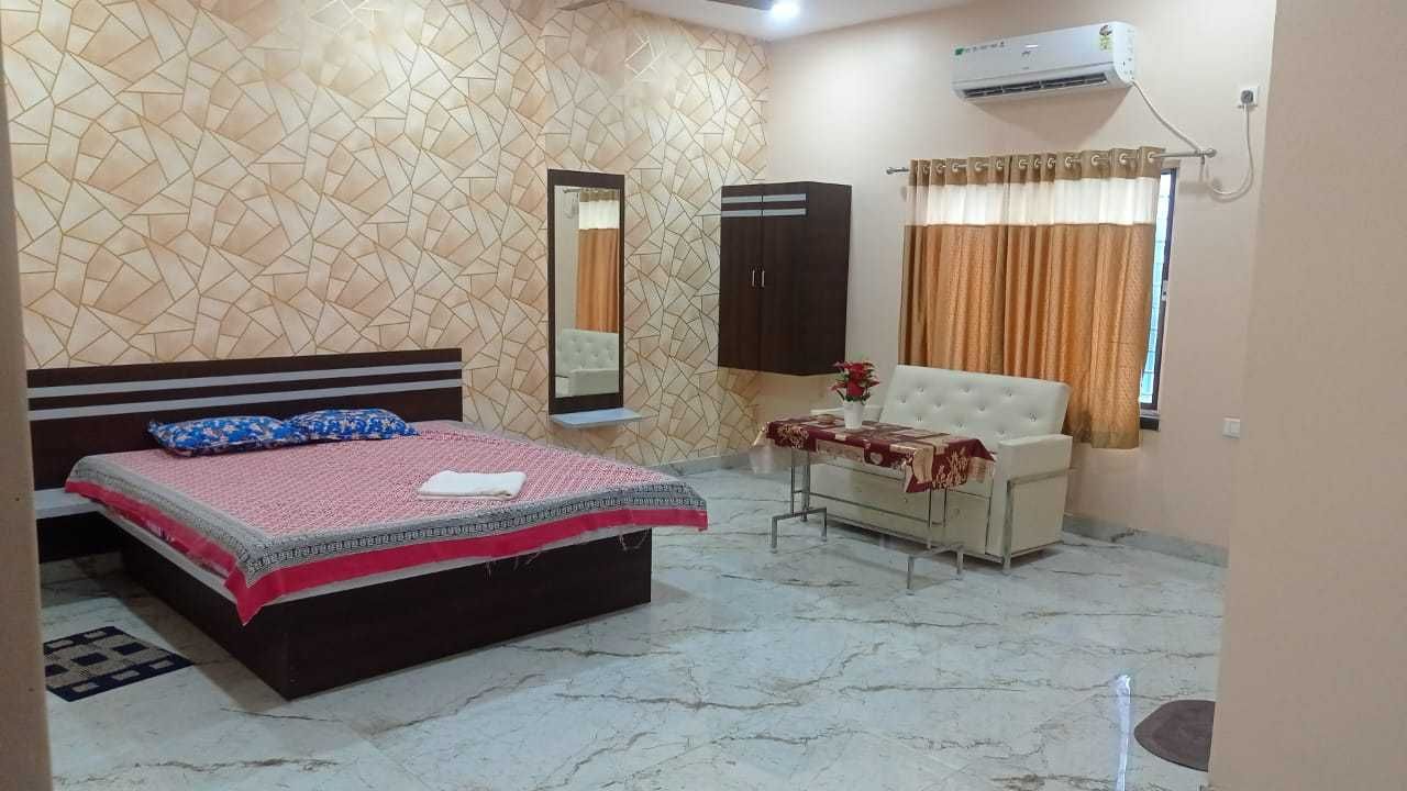 Un dormitorio con cama, armario, espejo, cómoda y aire acondicionado.