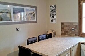 A modern kitchen with a large island, a framed landscape picture, and a motivational quote on the wall. - Les Jumeaux Right Le Touquet - Family House (Le Touquet)