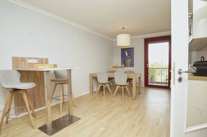 A dining area with a wooden table and chairs, a small stool, and a ceiling light fixture. - Modern vacation rental in a quiet location - Haus Fore Vacation Rental No. 202 (Lohme OT Ranzow)