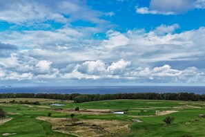 A golf course with a view of the ocean and a cloudy sky. - Modern vacation rental in a quiet location - Haus Fore Vacation Rental No. 202 (Lohme OT Ranzow)