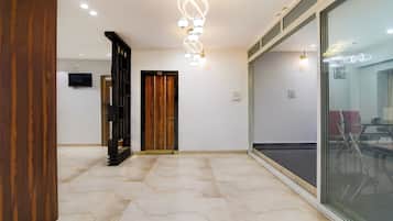 A hallway with a wooden door, a glass door, and a ceiling light fixture.