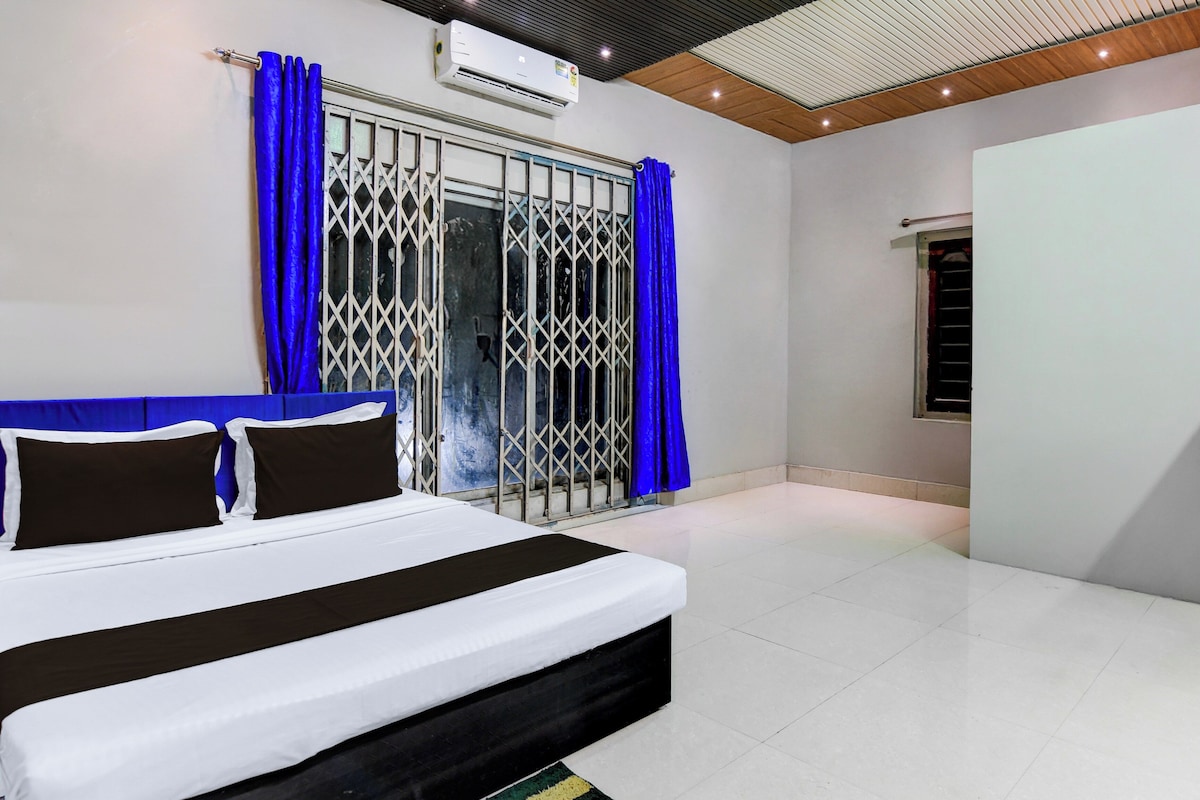A bedroom with a bed, curtains, and an air conditioning unit.