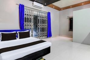 A bedroom with a bed, curtains, and an air conditioning unit. - Hotel O by OYO Green Eco Space (Kolkata)