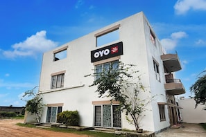 Um edifício de hotel moderno com uma placa indicando 'OYO Green Eco Space'.