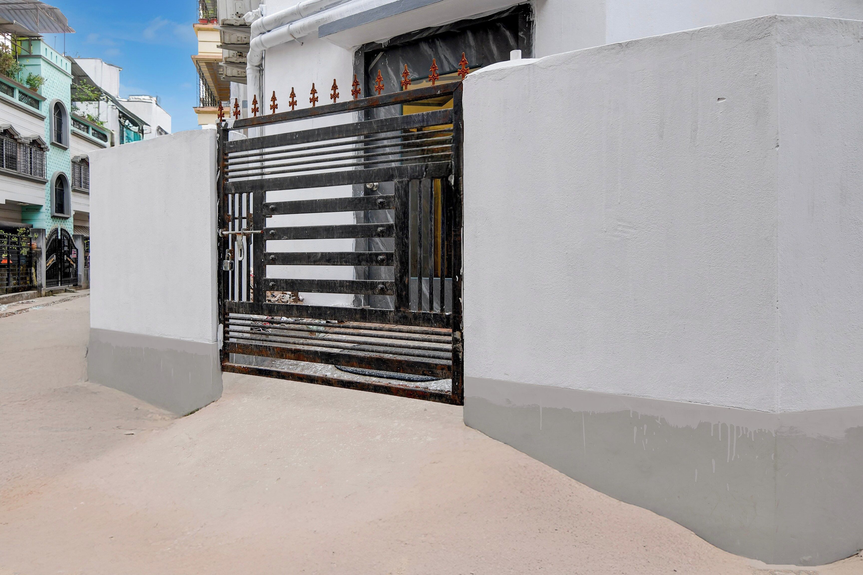 A gated entrance with a metal gate and a concrete wall.