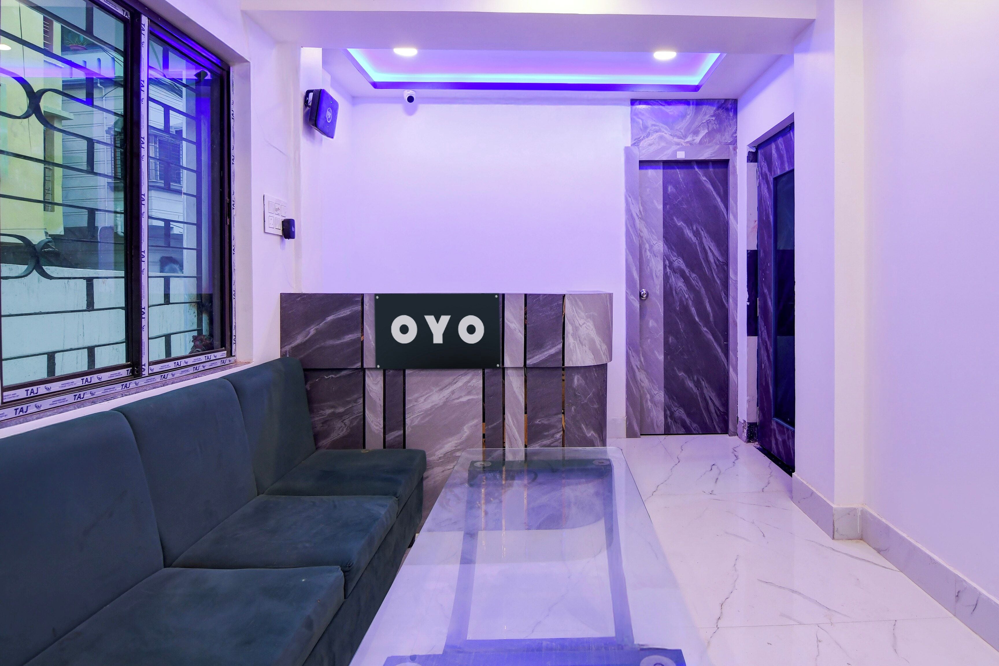 A modern interior with a sofa, a reception desk, and a marble wall.