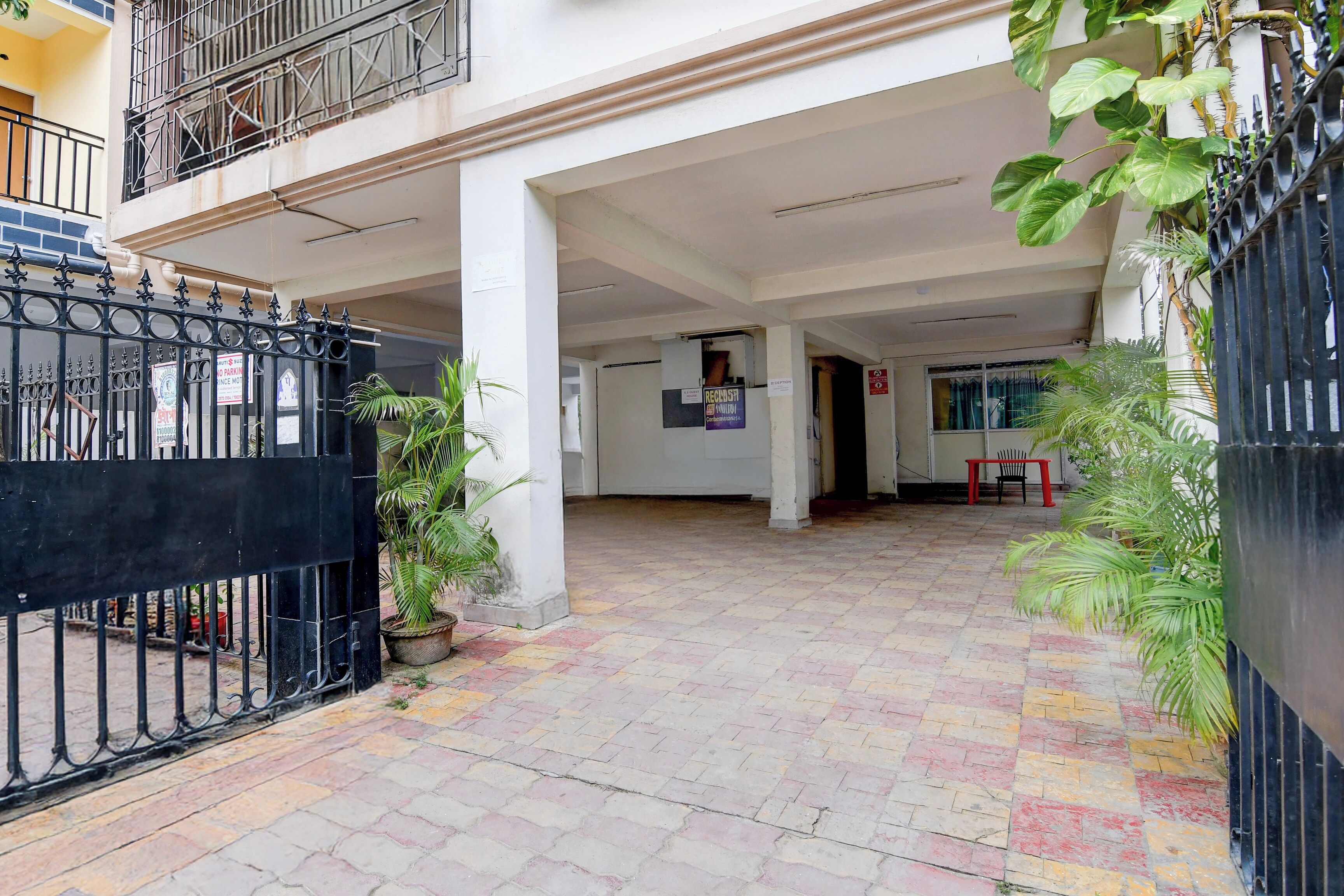 A gated entrance with a tiled pathway leading to a building with a balcony.