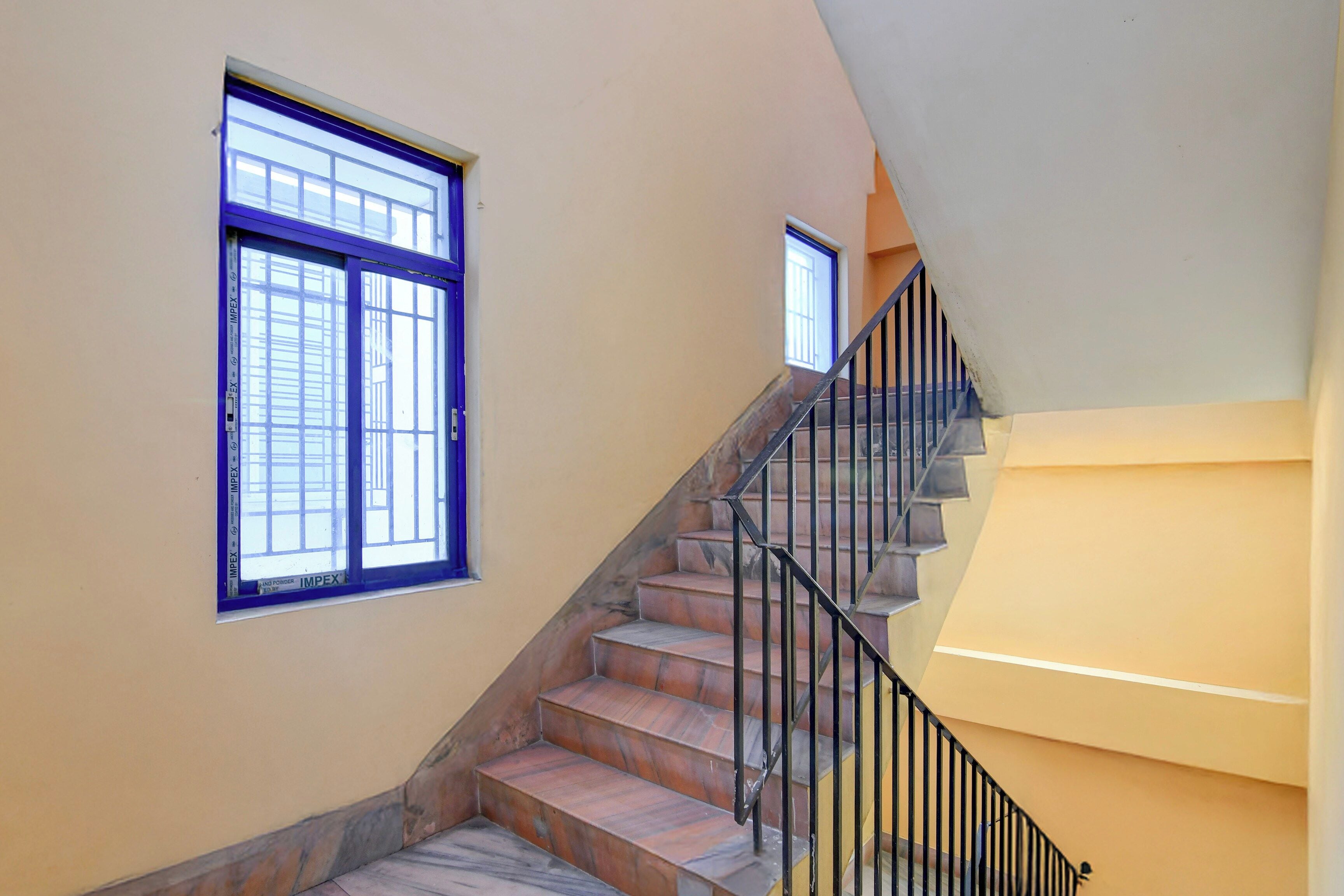 A staircase with a handrail and a window on the landing.