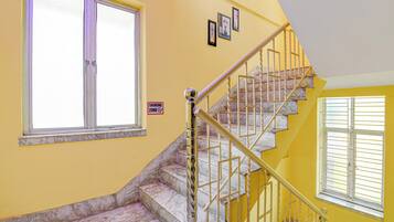 A staircase with marble steps and a yellow wall.