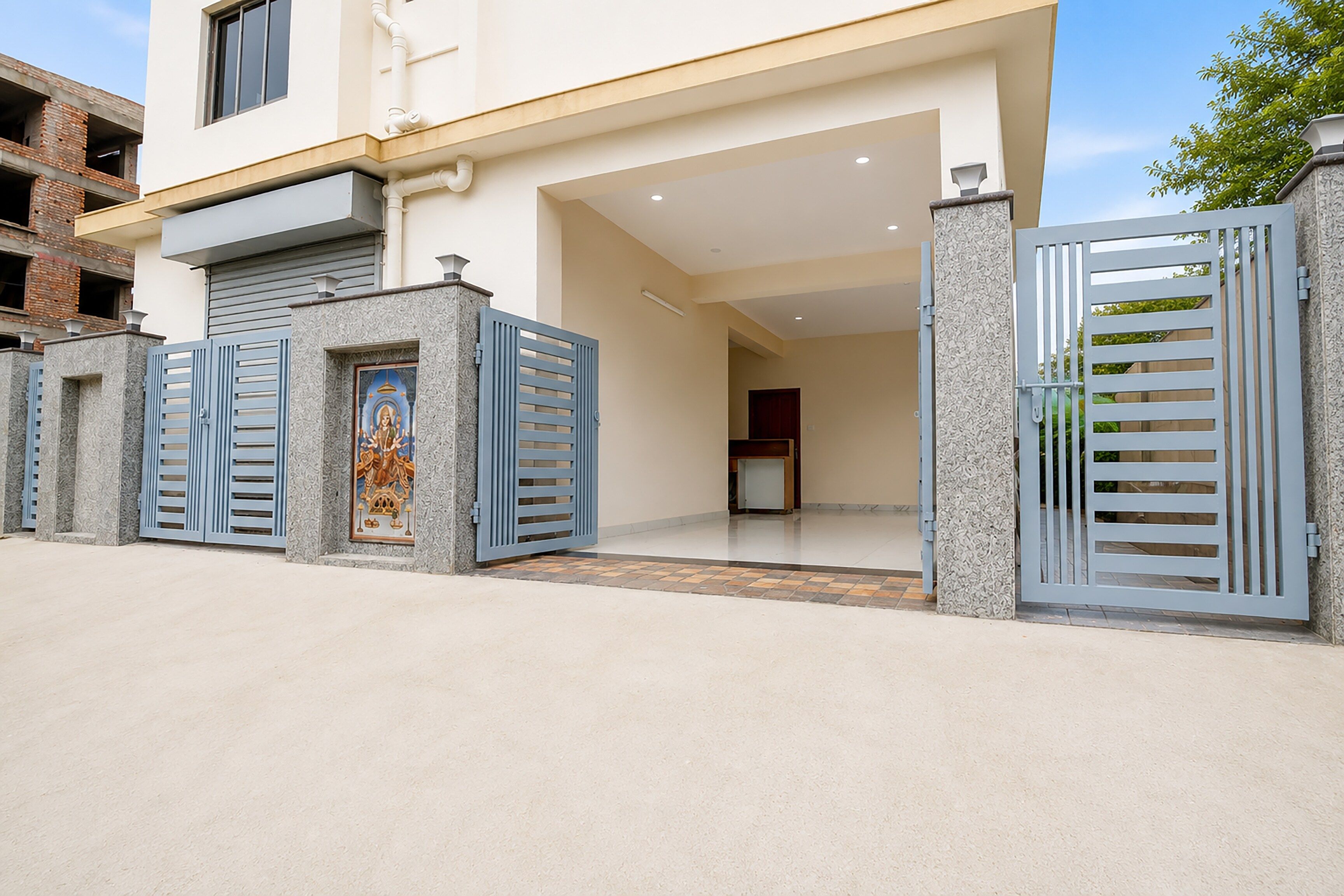 A modern two-story house with a gated entrance, a visible door, and a small porch area.