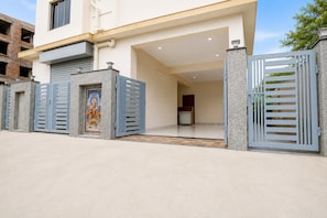 A modern two-story house with a gated entrance, a visible door, and a small porch area. - Hotel O NamaStay (Barasat)