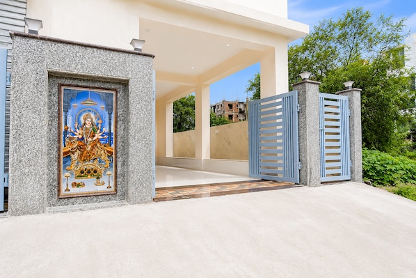A gated entrance with a decorative door and a view of a building in the background. - Hotel O NamaStay (Barasat)