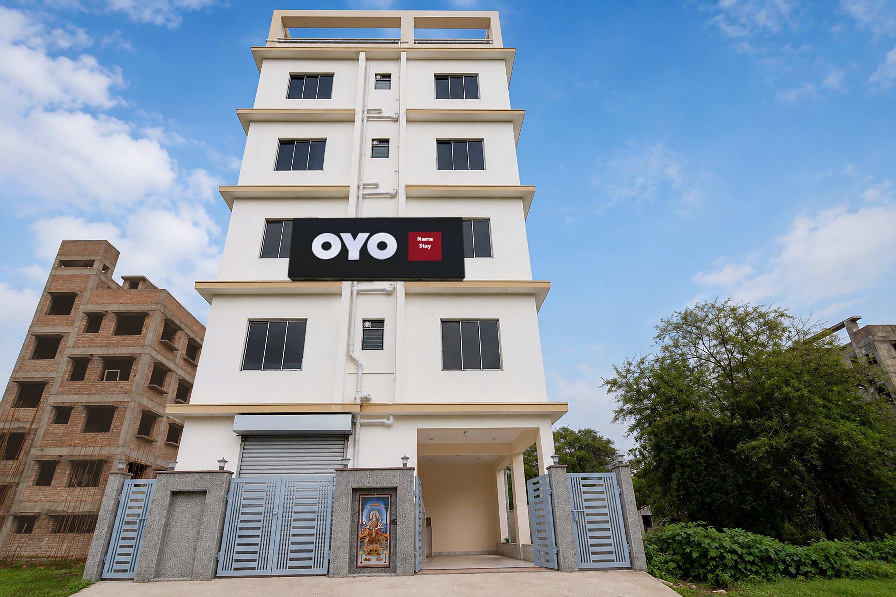 Un hotel de varios pisos con un llamativo letrero de 'OYO' en la fachada.