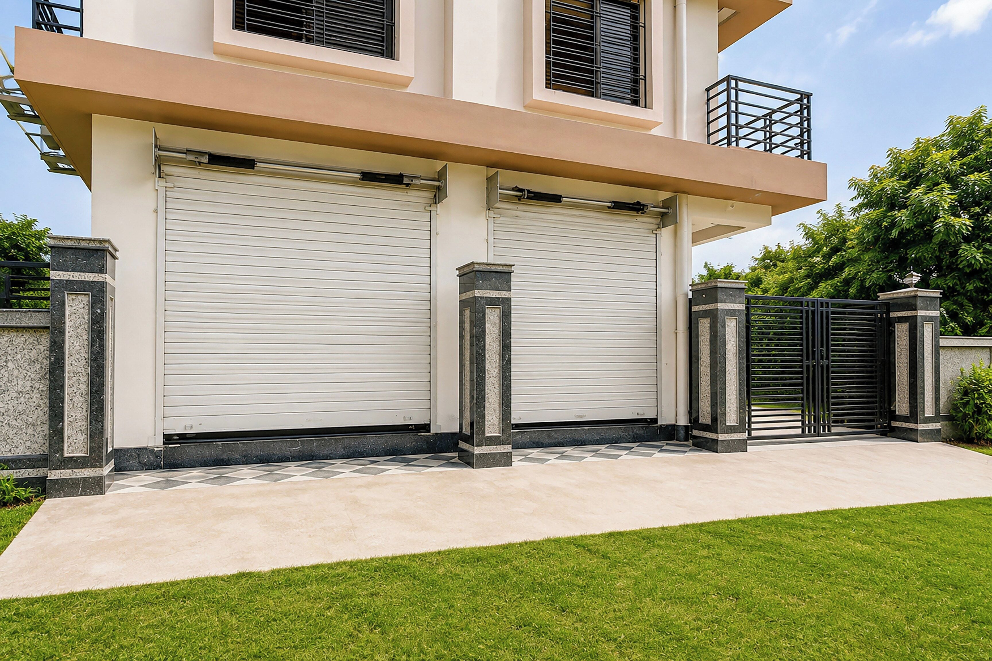 A modern two-story building with a closed garage door and a gated entrance.
