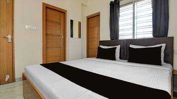 Un dormitorio con cama, armario de madera y ventana con cortinas.
