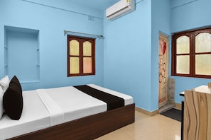 A bedroom with a bed, a window, an air conditioning unit, and a door. - Hotel O Krivaan Guest House (Kolkata)