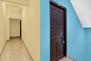 Un pasillo con una puerta de madera oscura y una pared azul.