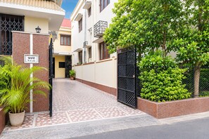 A residential building with a tiled entrance, a potted plant, and a metal gate. - Hotel O Ghosh Guest House (Barasat)