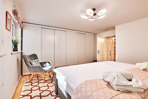 Ein Schlafzimmer mit Bett, Stuhl, Kleiderschrank und Deckenleuchte.
