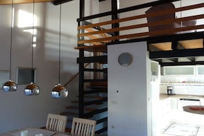 A modern interior with a dining area, a staircase, and a kitchen. - Holiday home with 2 bedrooms (Birkenhördt)