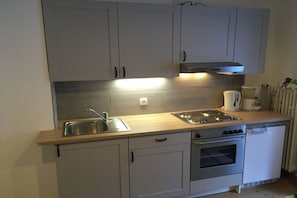 A compact kitchen with a sink, stove, and a coffee maker. - Holiday apartment with 2 bedrooms (Mittenwald)