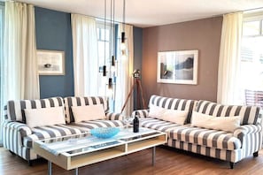 Ein Wohnzimmer mit gestreiften Sofas, einem Couchtisch und einem gerahmten Bild an der Wand.