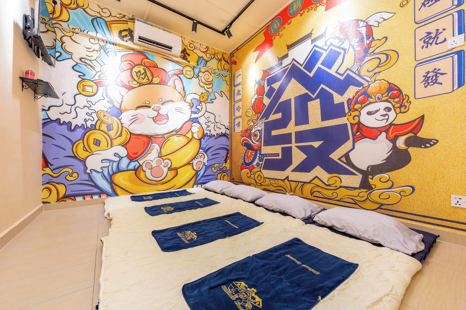 Una habitación de hotel con una cama grande, un mural en la pared y un ventilador de techo.