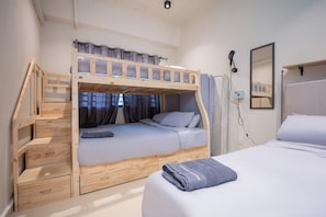 A bunk bed room with a desk and a mirror.