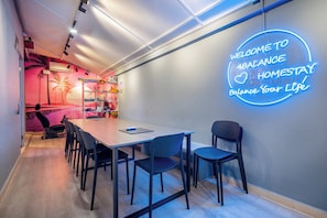 A modern office space with a neon sign reading 'WELCOME TO 4BALANCE HOMESTAY Balance Your Life.'