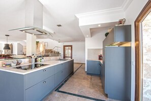 A modern kitchen with a central island, built-in appliances, and a view to the living area. - Finca in Porreres with swimming pool (Porreres)