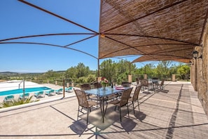 An outdoor patio with a pool, dining area, and a view of the landscape. - Finca in Porreres with swimming pool (Porreres)