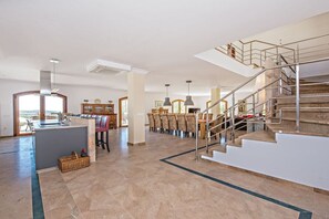 A spacious living area with a kitchen, dining area, and a staircase leading to an upper level. - Finca in Porreres with swimming pool (Porreres)