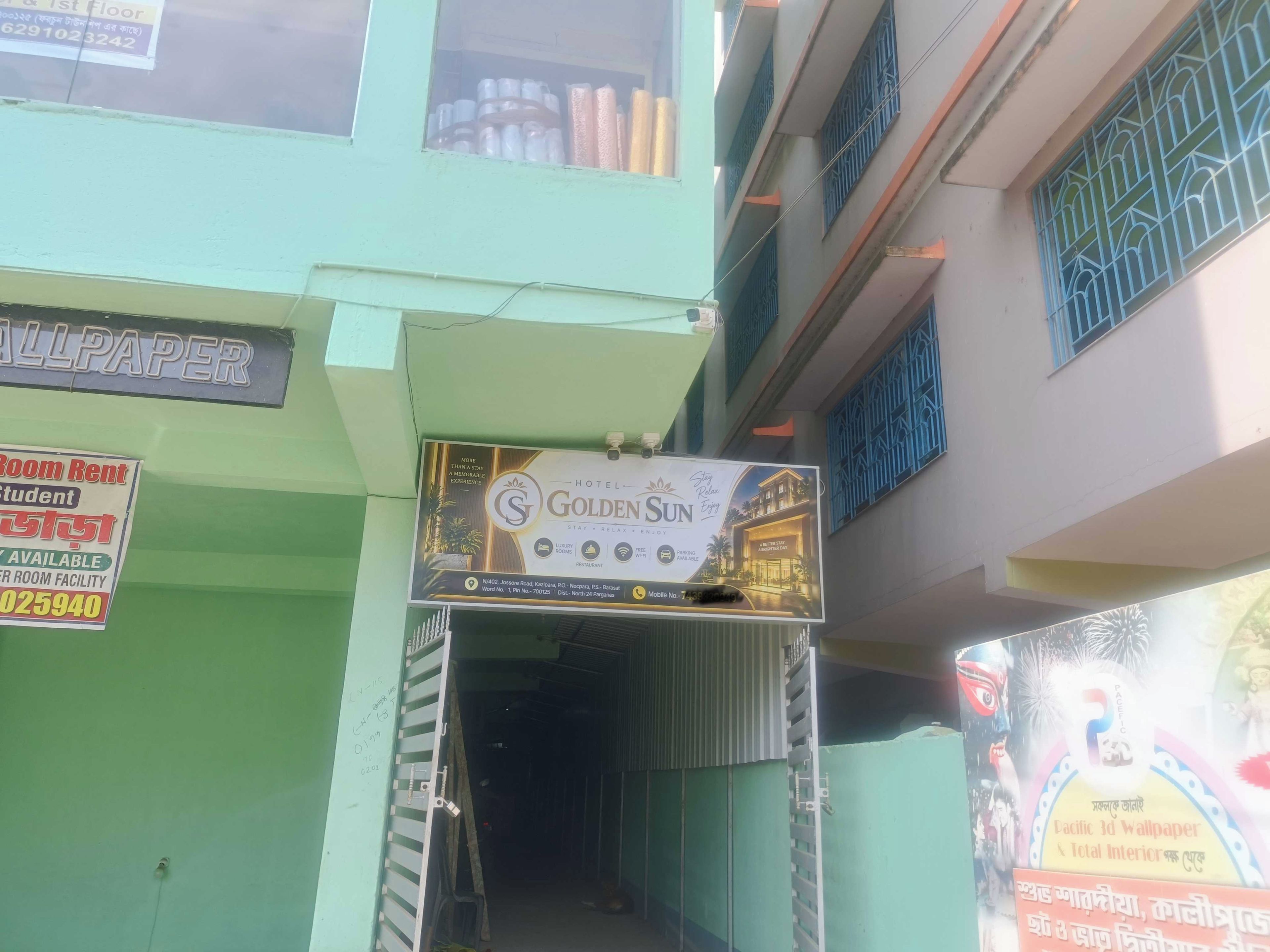 A building with a sign for 'Golden Sun Hotel' and a 'Room Rent' sign for students.
