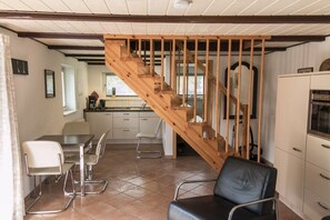 Ein Essbereich mit einer Holztreppe, die in eine obere Etage führt.