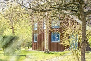 A modern building with a wooden facade, surrounded by trees and a grassy area. - Up to 6 holidaymakers (Ostseeheilbad Zingst)