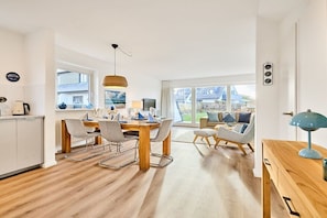 A modern kitchen with a dining area, large windows, and a view of the outside. - Holiday home with 3 bedrooms (Wenningstedt)