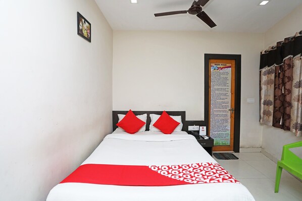 A hotel room with a bed, a ceiling fan, a framed picture on the wall, and a hotel rules notice. - Hotel O South Inn (Kolkata)