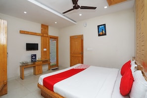 A hotel room with a bed, a desk, a television, and a ceiling fan. - Hotel O South Inn (Kolkata)