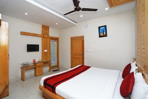 A hotel room with a bed, wooden wardrobe, desk, and a television. - Hotel O South Inn (Kolkata)