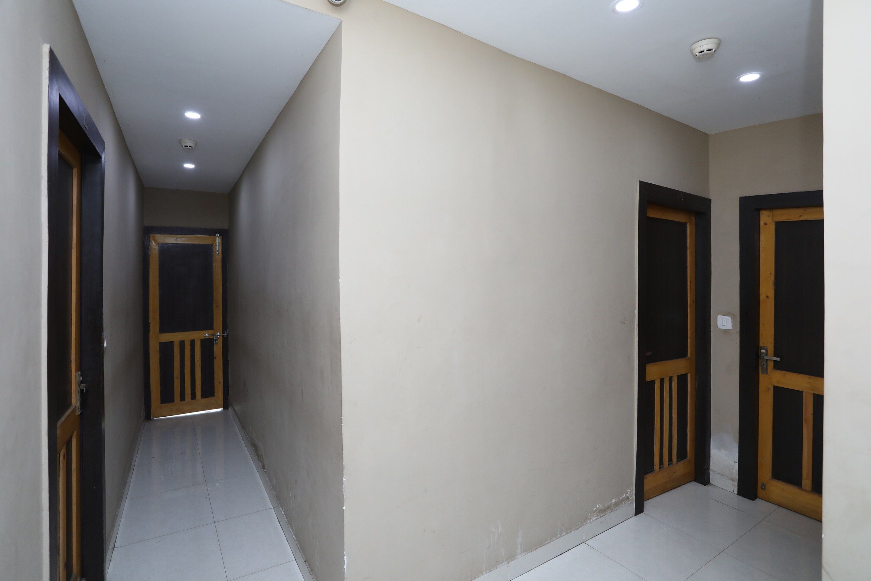 A corridor with two doors, one on each side, and a ceiling with recessed lighting.