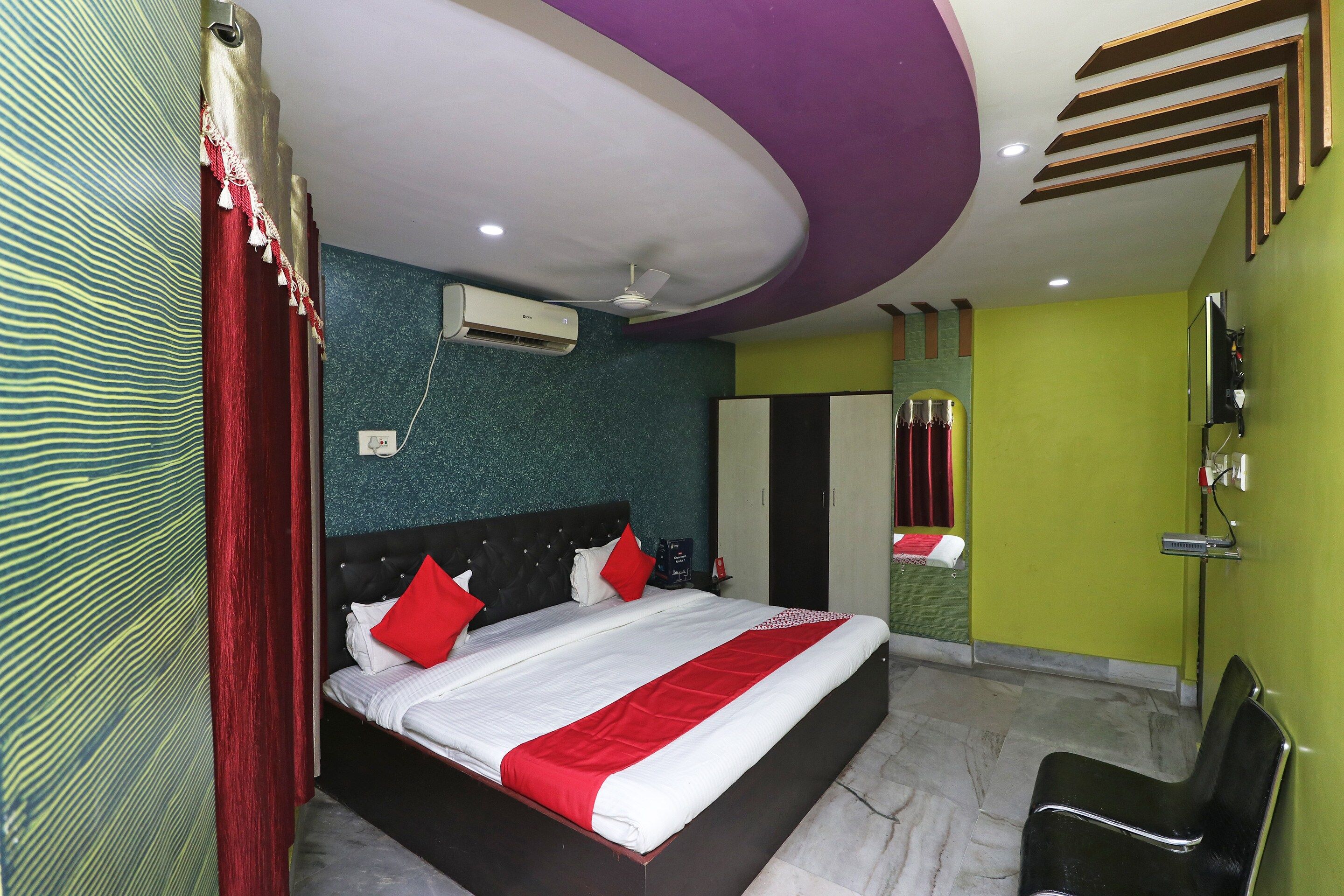 Una habitación de hotel con cama, espejo, armario y televisión.